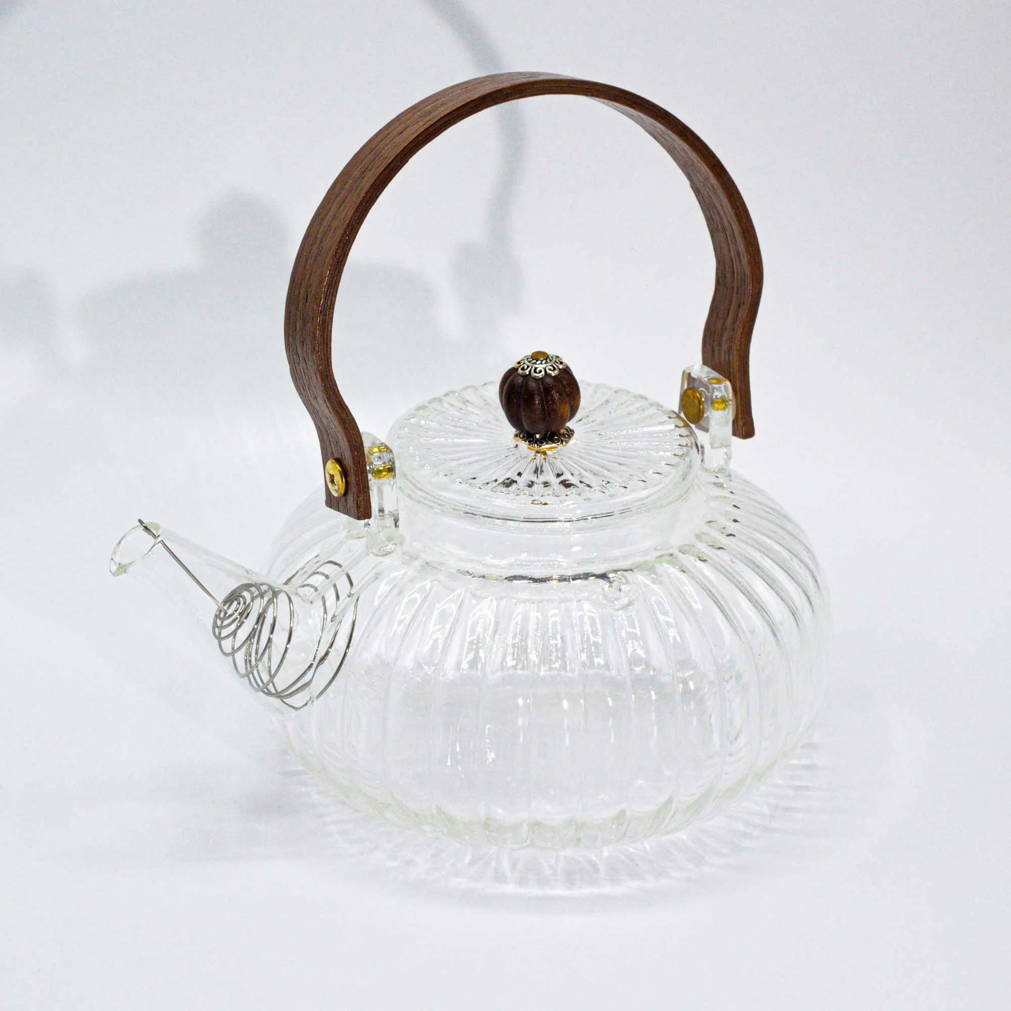 Clear glass teapot with a ribbed design, wooden handle, and wooden knob on the lid, displayed on a white background.