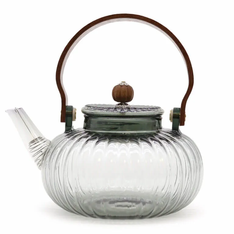 Clear glass teapot with a ribbed design, short spout, metal lid topped with a wood knob, and a curved wooden handle.