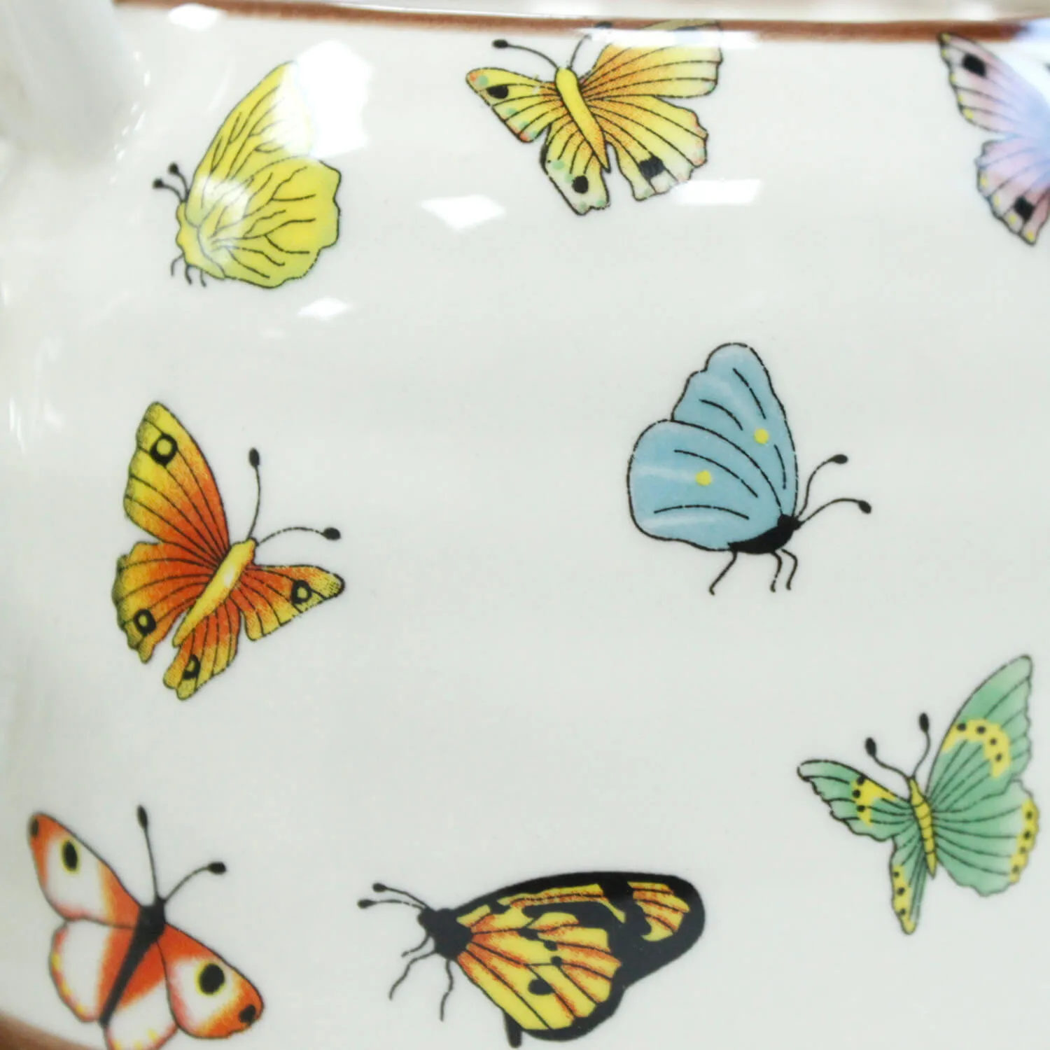 A white ceramic surface with colorful butterfly illustrations, including yellow, orange, blue, green, and multicolored butterflies.