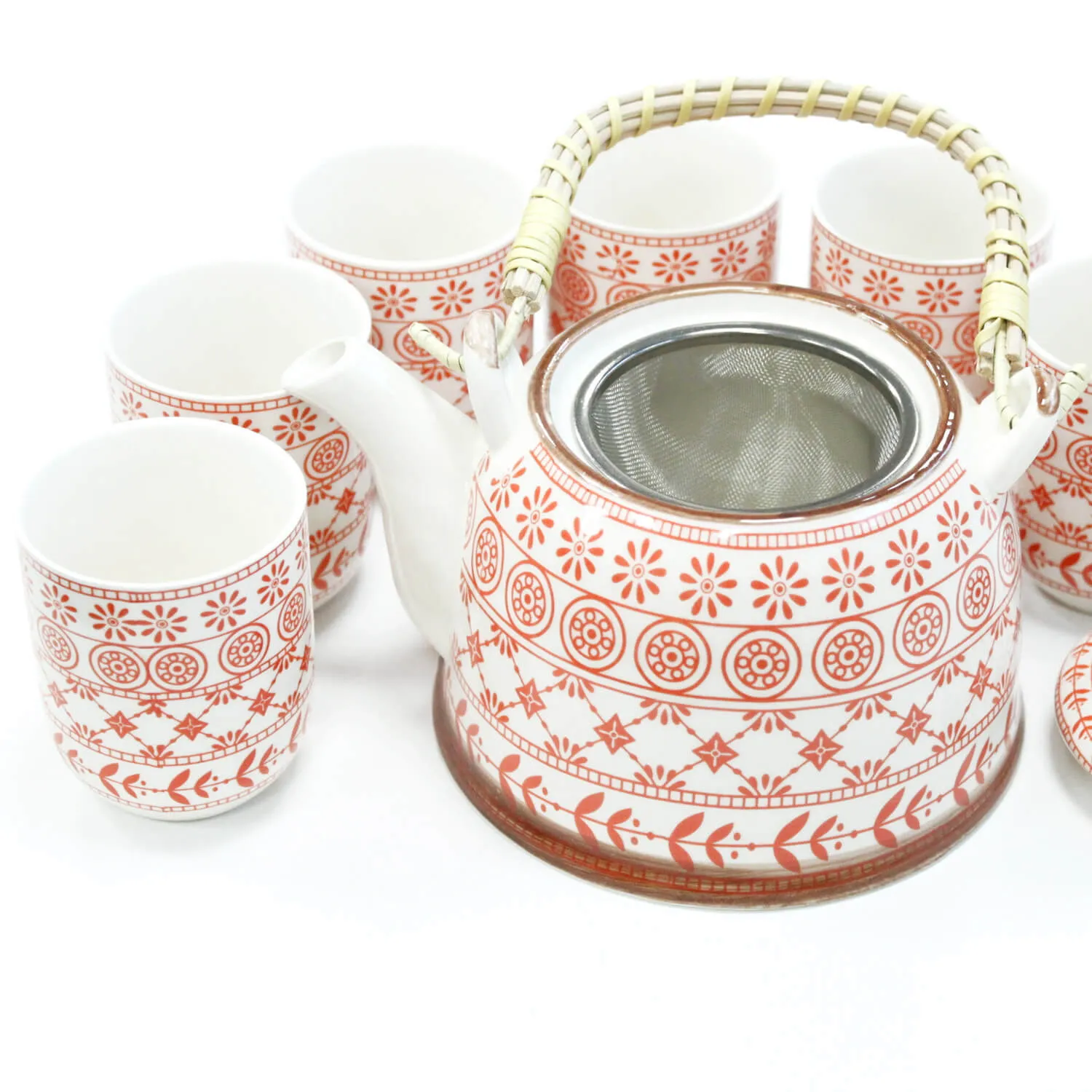 A ceramic teapot with a metal strainer and a bamboo handle, surrounded by five matching cups, all featuring a red and white geometric pattern.