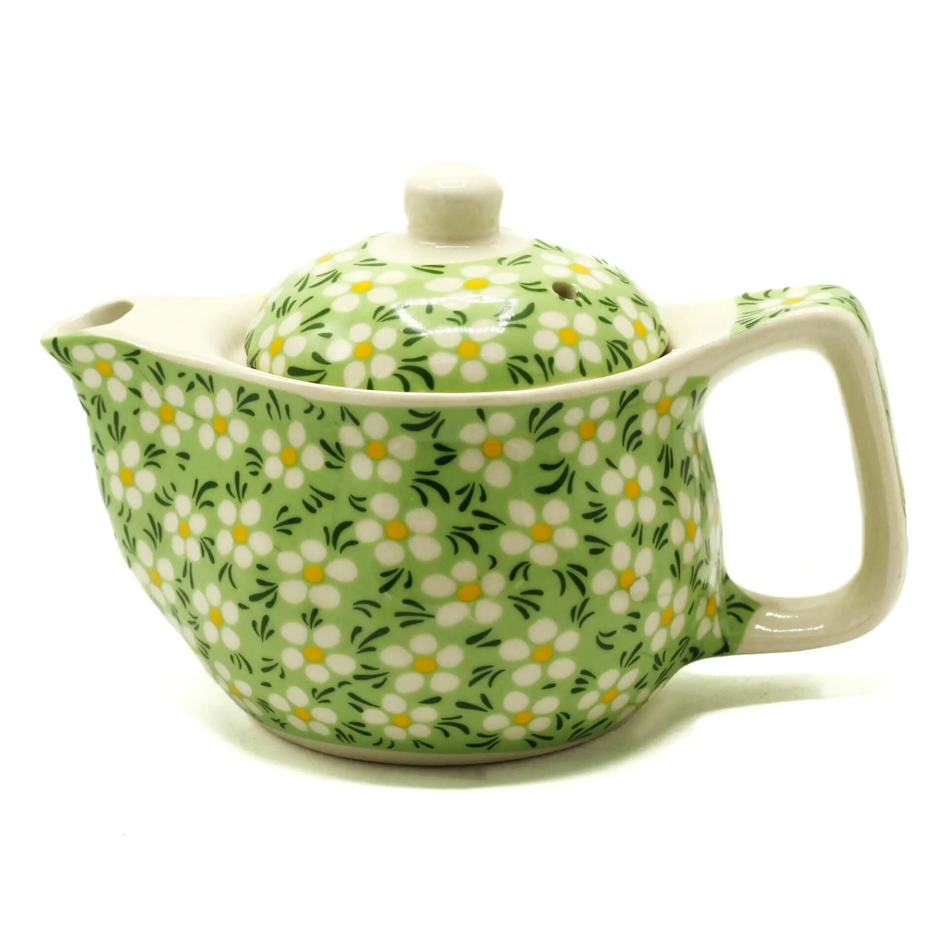 A ceramic teapot with a handle and spout, decorated with a green background and white and yellow floral pattern.