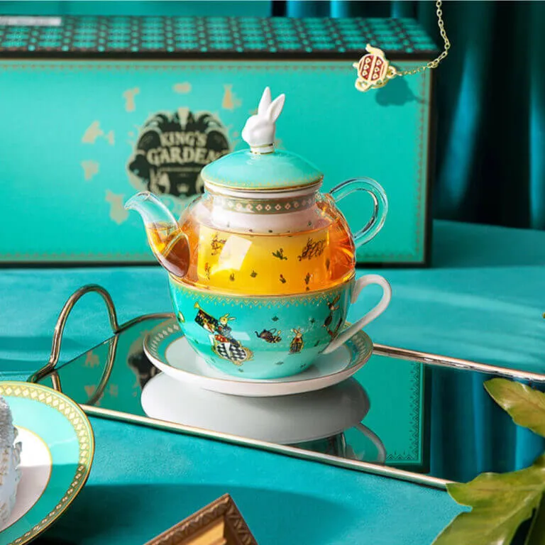 The Alice in Wonderland Inspired Rabbit Teapot Set from the Luxury Afternoon Tea Collection features a charming teal teapot with a rabbit-shaped lid, matching teacup, and a