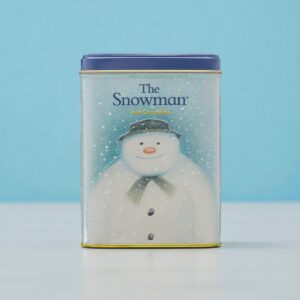 A rectangular tin with a blue lid features an illustration of a snowman wearing a hat and scarf, labeled